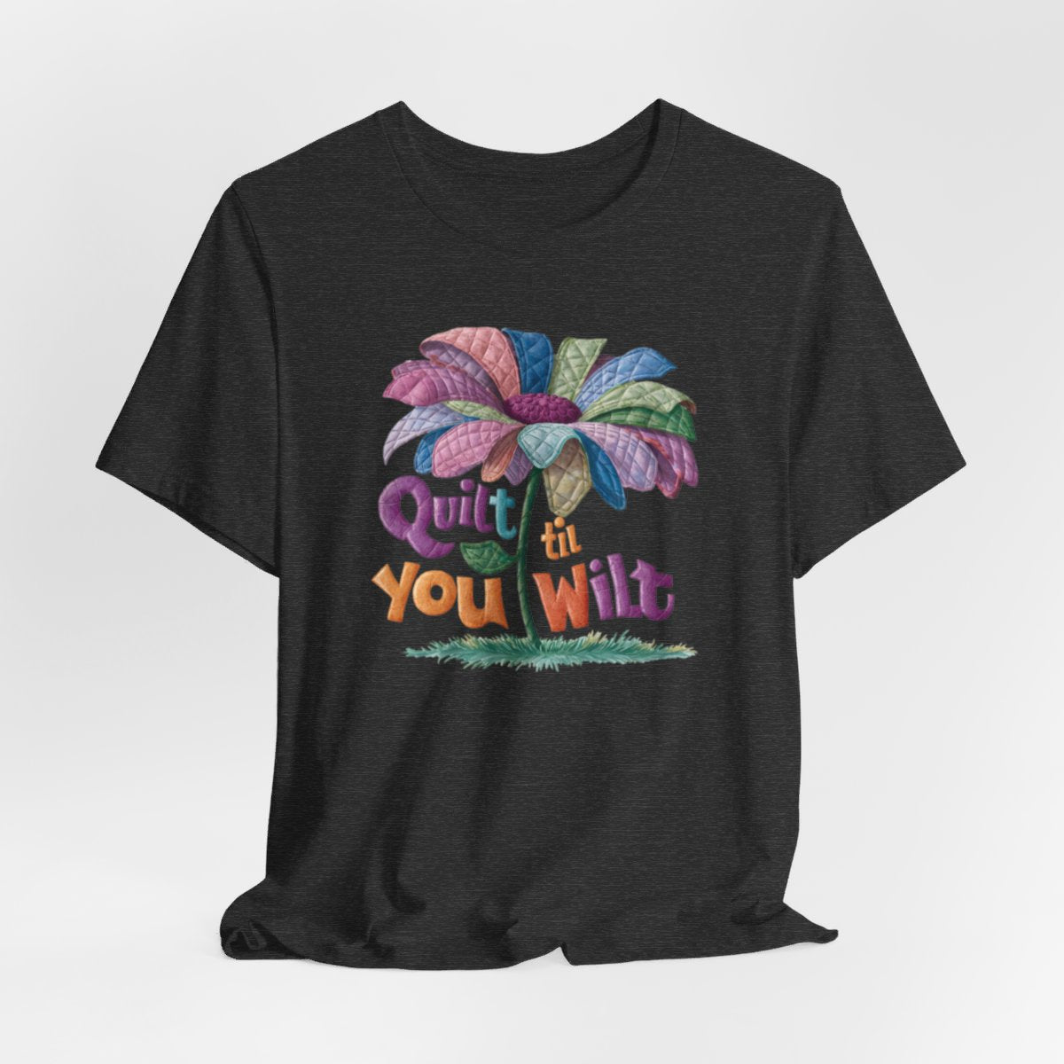 A Dark Grey Heather funny quilting T-Shirt with the phrase Quilt 'Till You Wilt showing a cheerful, but slightly wilted quilted flower design