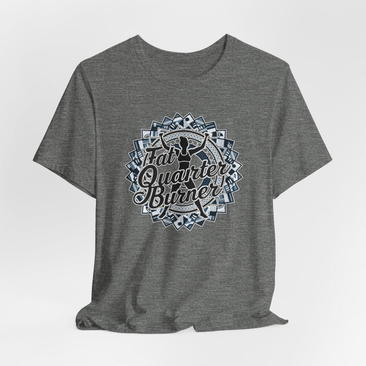 A Deep Heather T-Shirt featuring a patchwork border surrounding silhouette of woman lifting weights. Text reads "Fat Quarter Burner" in bold script.