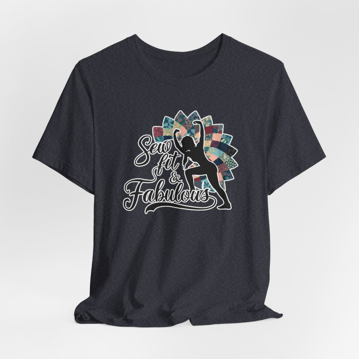A Heather Navy T-Shirt featuring a black silhouette of woman with raised arms against colorful patchwork background. Text reads "Sew fit & Fabulous" in stylized script.