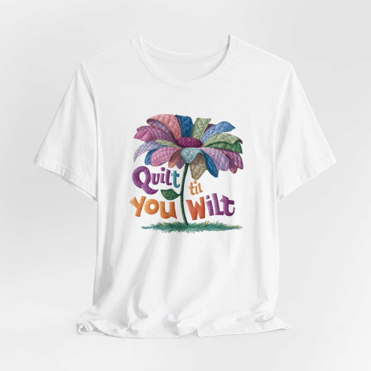 A White funny quilting T-Shirt with the phrase Quilt 'Till You Wilt showing a cheerful, but slightly wilted quilted flower design