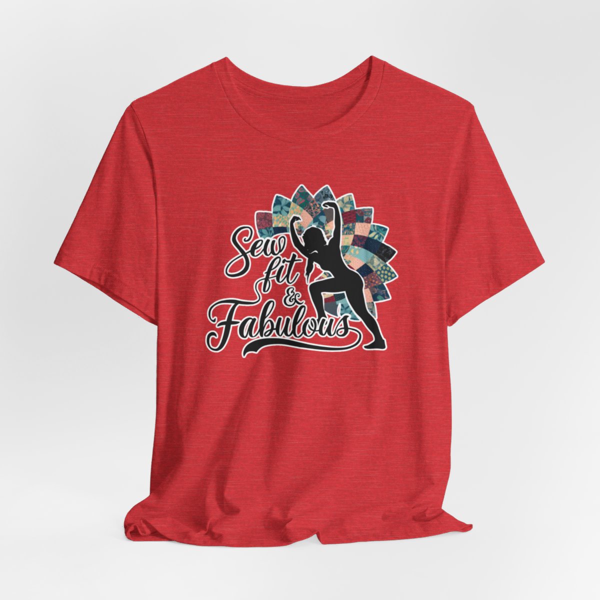 A Heather Red T-Shirt featuring a black silhouette of woman with raised arms against colorful patchwork background. Text reads "Sew fit & Fabulous" in stylized script.