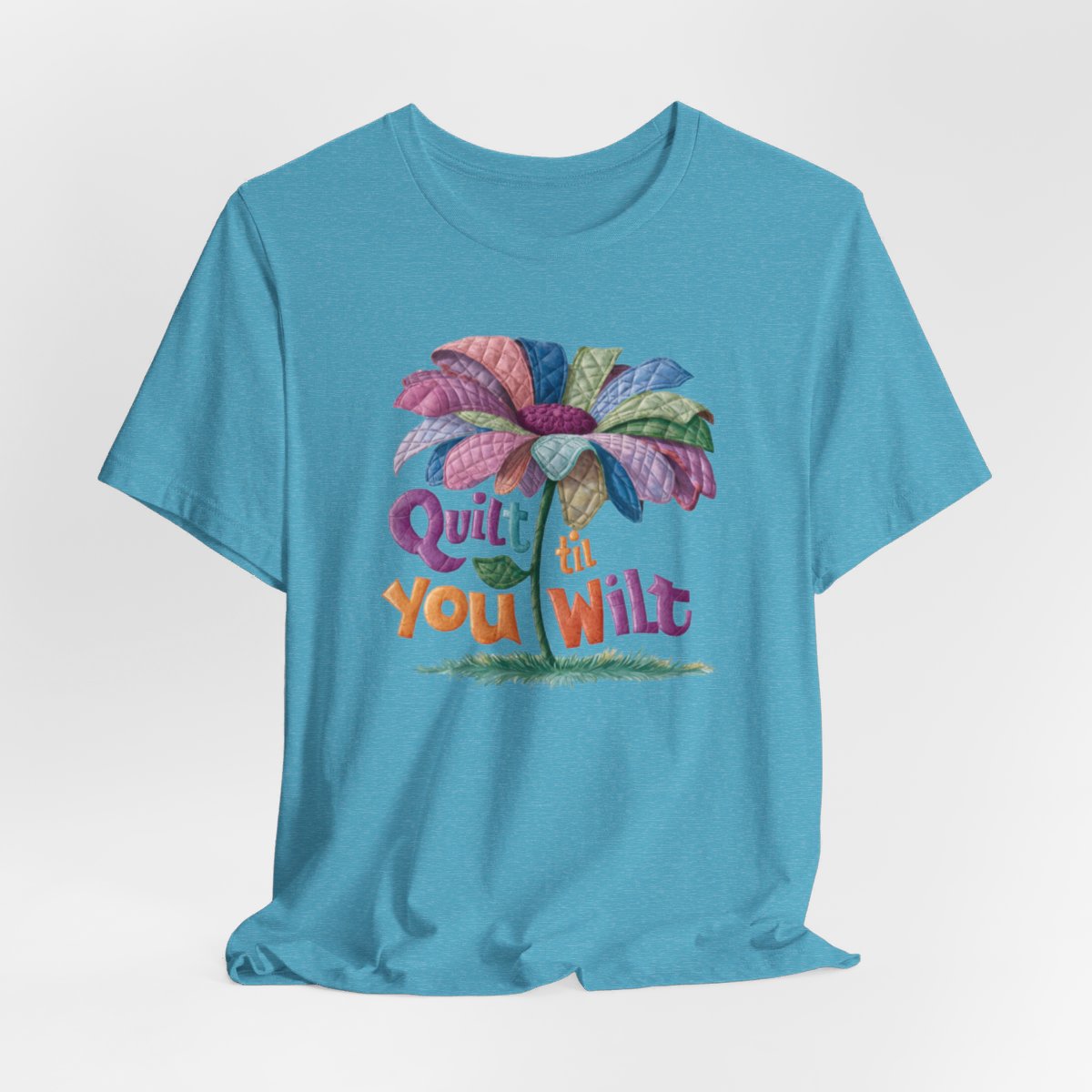 A Heather Aqua funny quilting T-Shirt with the phrase Quilt 'Till You Wilt showing a cheerful, but slightly wilted quilted flower design