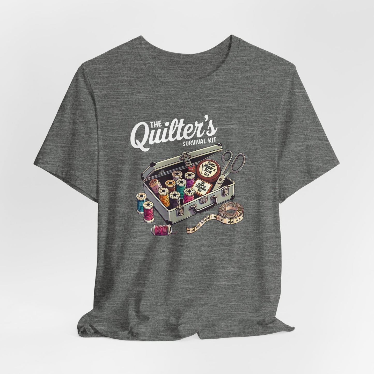 A Deep Heather t-shirt featuring a whimsical illustration of a quilter’s survival kit with colorful thread spools, scissors, and a tape measure, perfect for sewing and quilting enthusiasts.