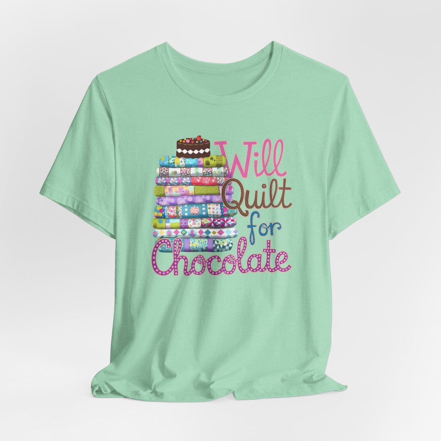 A Heather Mint t-shirt featuring a whimsical design of a colorful stack of quilts topped with a chocolate cake and the phrase 'Will Quilt for Chocolate,' perfect for quilters who love sweets.
