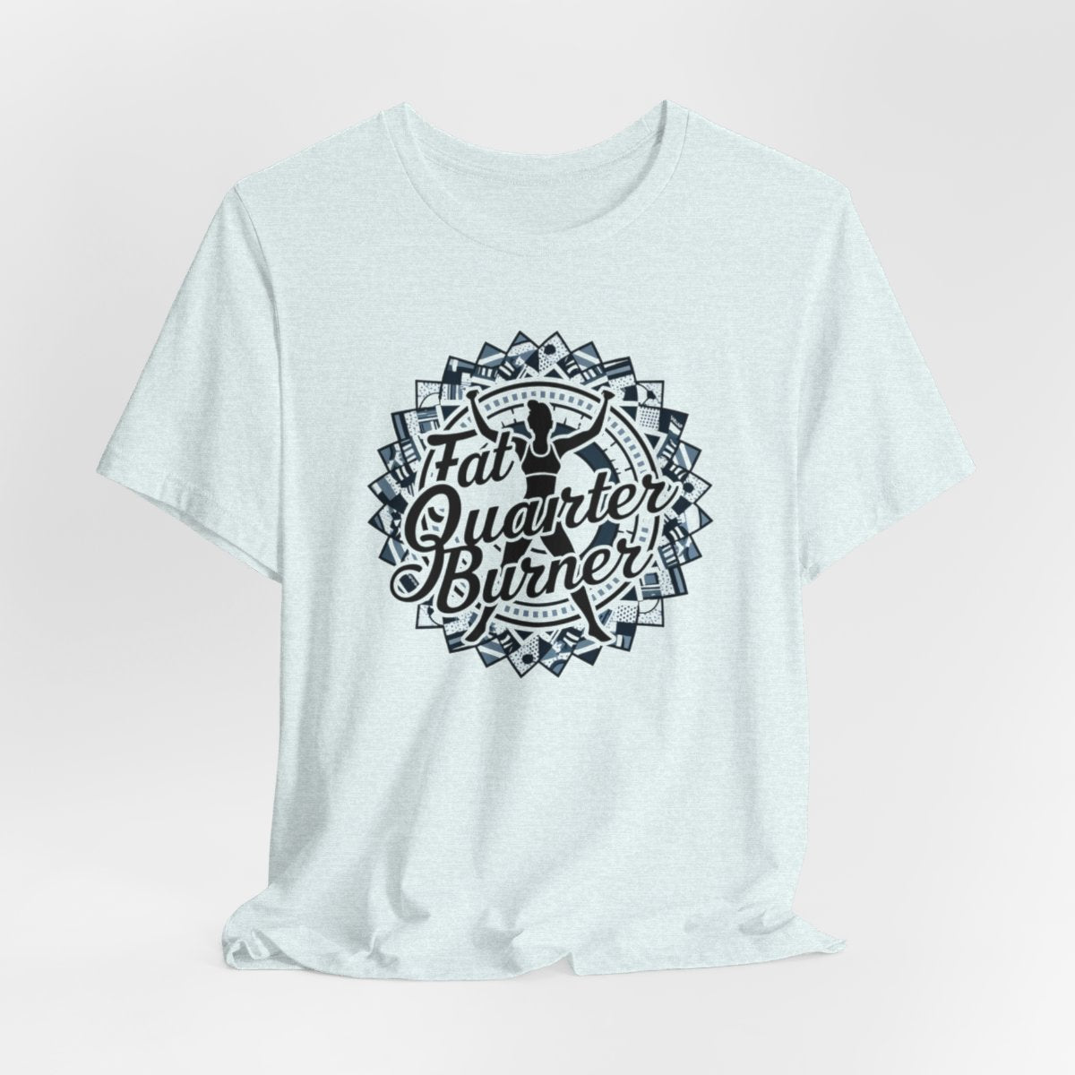 A Heather Ice Blue T-Shirt featuring a patchwork border surrounding silhouette of woman lifting weights. Text reads "Fat Quarter Burner" in bold script.