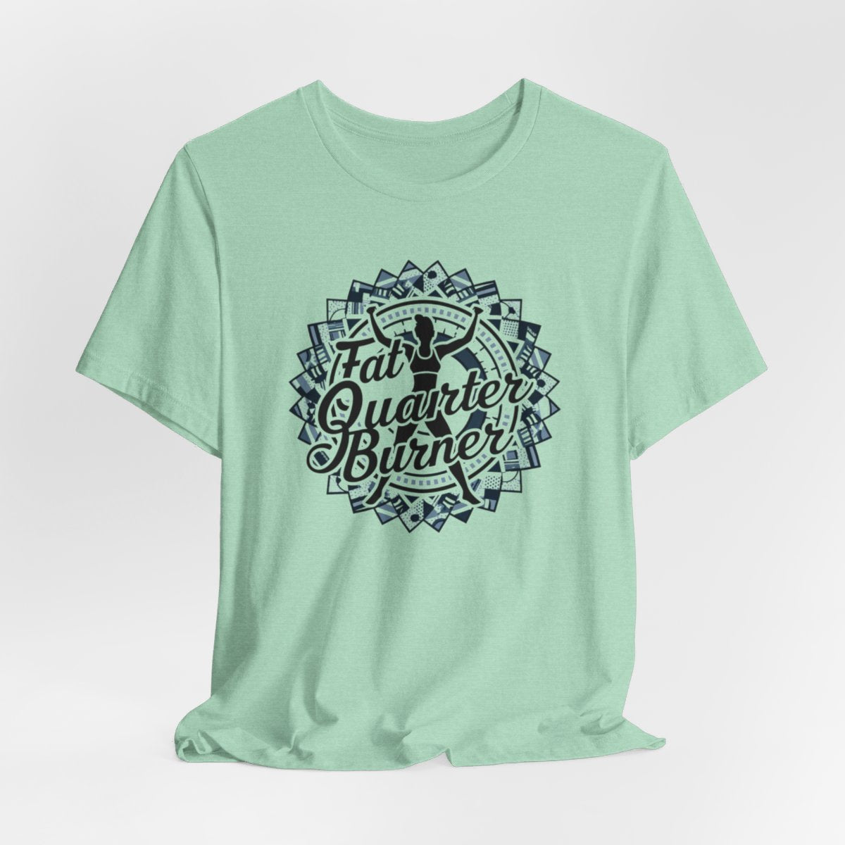 A Heather Mint T-Shirt featuring a patchwork border surrounding silhouette of woman lifting weights. Text reads "Fat Quarter Burner" in bold script.