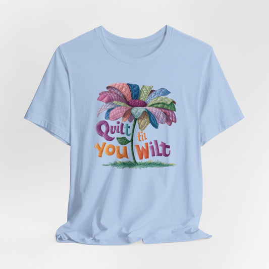 A Baby Blue funny quilting T-Shirt with the phrase Quilt 'Till You Wilt showing a cheerful, but slightly wilted quilted flower design