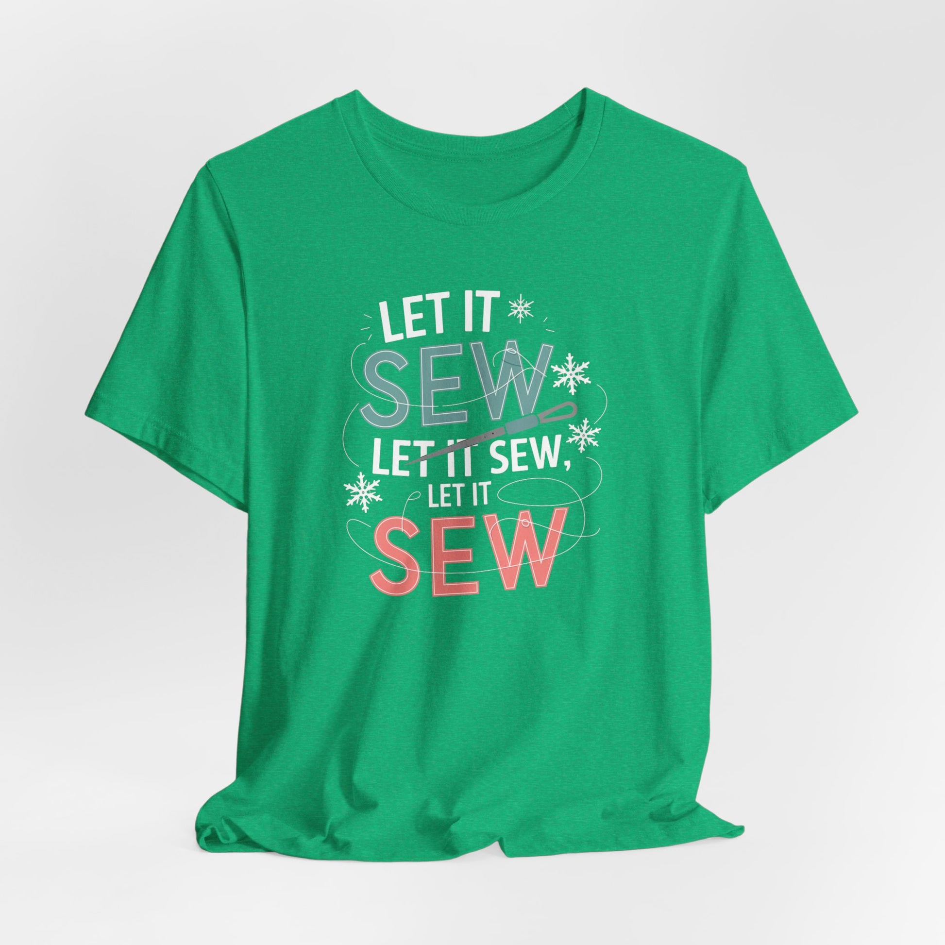 A Heather Kelly christmas quilting t-shirt featuring the phrase "Let it Sew, Let it Sew, Let it Sew" featuring a needle and thread weaving through the letters, accented by snowflakes to bring out the holiday theme.