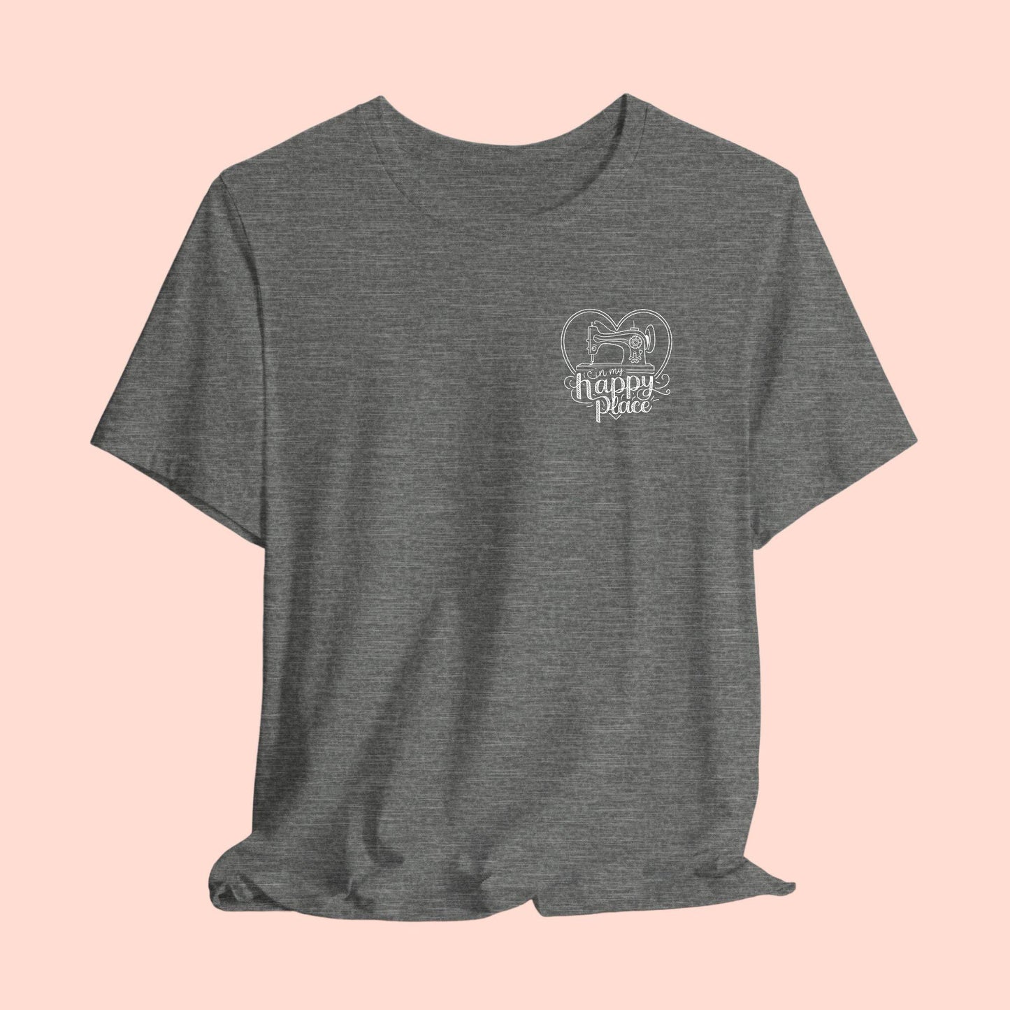 A funny quilting T-shirt design showing a sewing machine inside a heart shape with decorative swirls. Text reads "In my happy place" in mixed fonts, emphasizing quilting as a source of joy and contentment for enthusiasts.