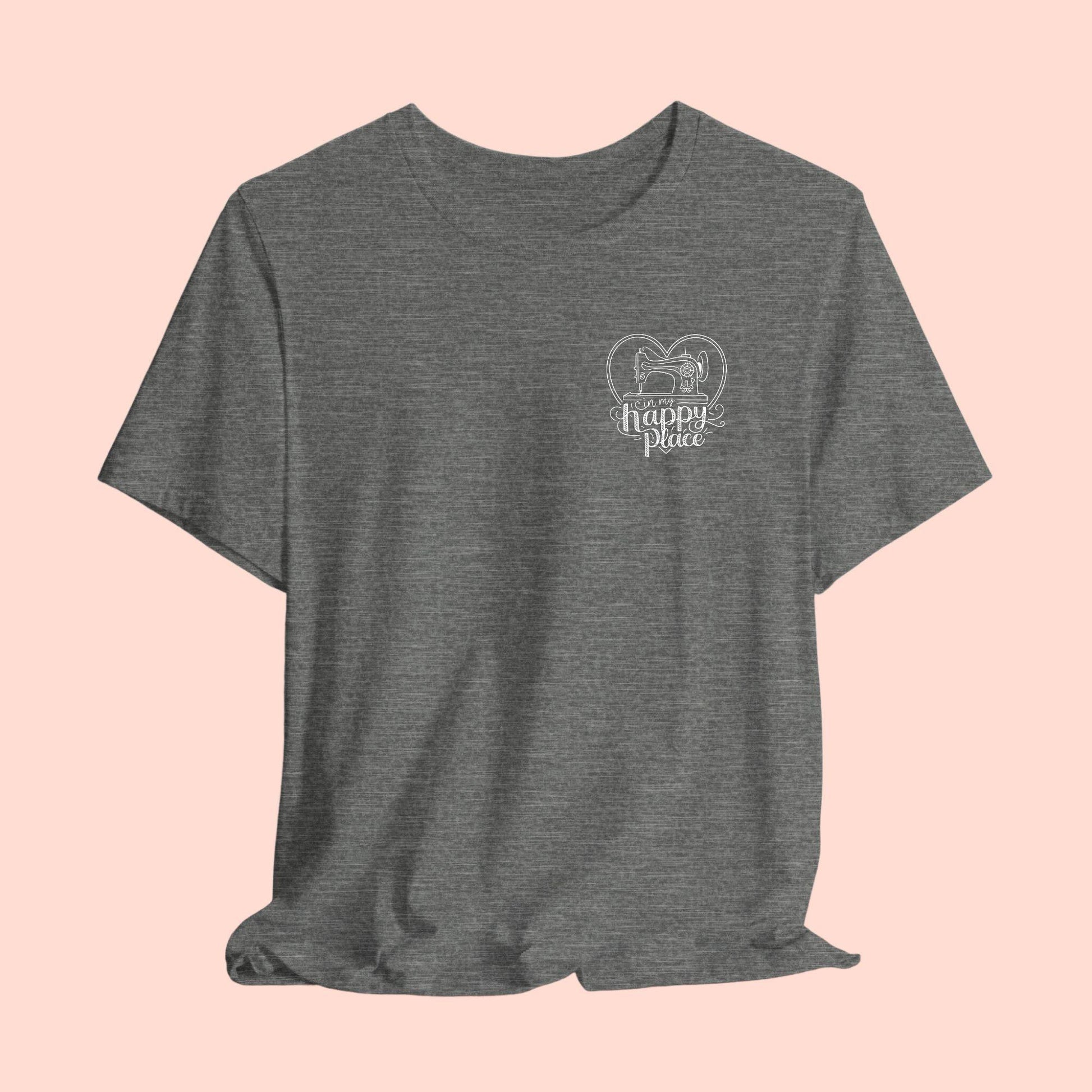 A funny quilting T-shirt design showing a sewing machine inside a heart shape with decorative swirls. Text reads "In my happy place" in mixed fonts, emphasizing quilting as a source of joy and contentment for enthusiasts.