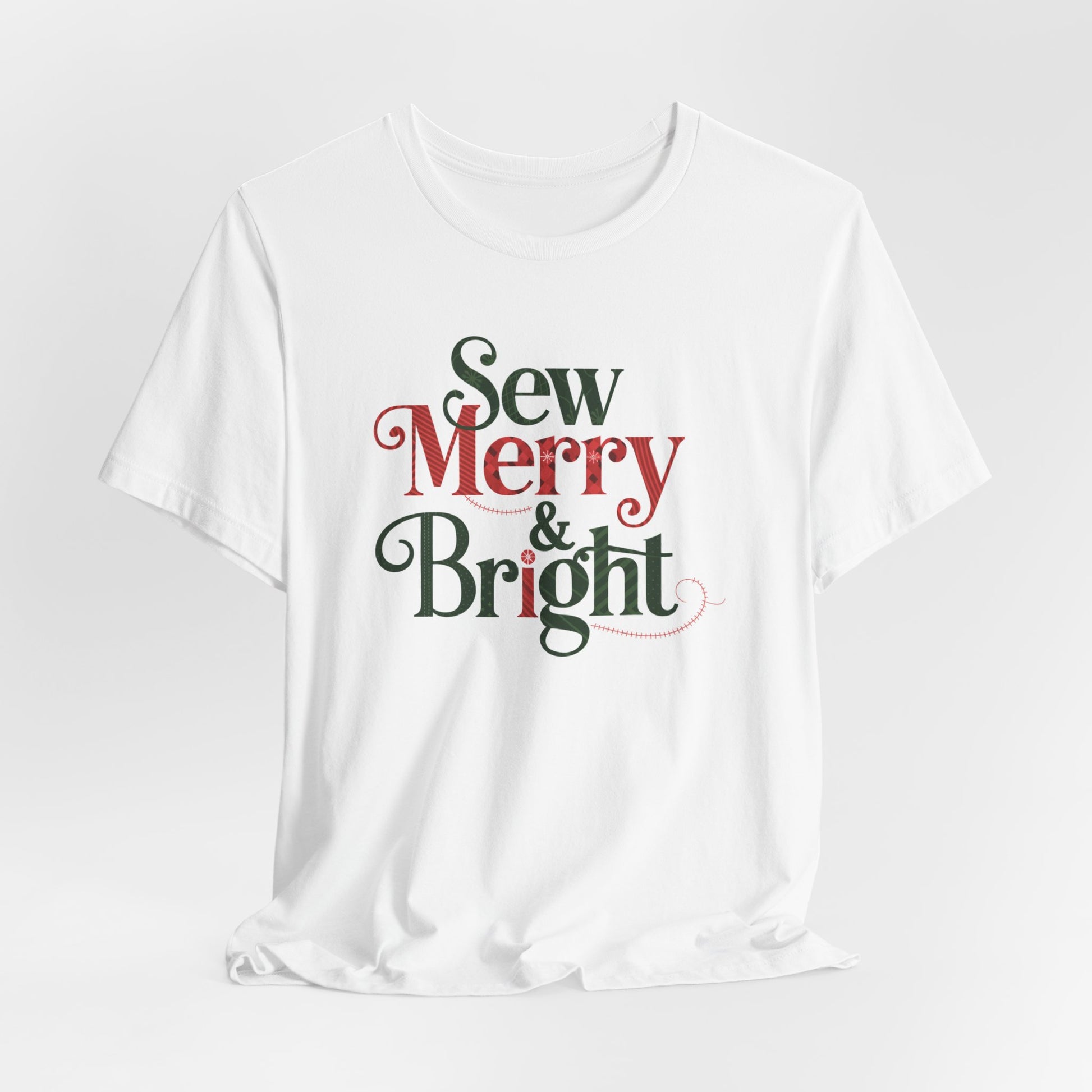 A White t-shirt with the phrase "Sew Merry & Bright," incorporating sewing-inspired elements and holiday-themed accents, such as stitching lines and festive patterns.