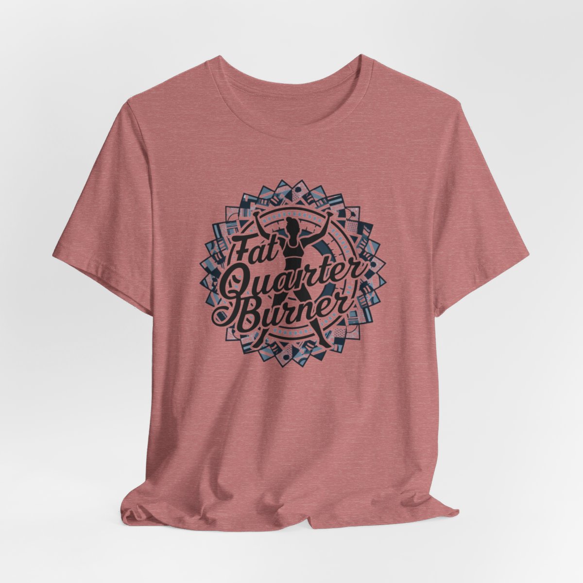 A Heather Mauve T-Shirt featuring a patchwork border surrounding silhouette of woman lifting weights. Text reads "Fat Quarter Burner" in bold script.