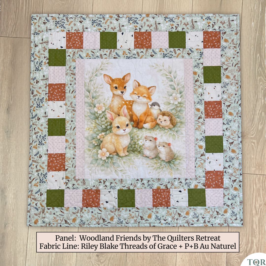 Woodland friends baby quilt panel sewn into a finished baby quilt — handmade baby shower gift