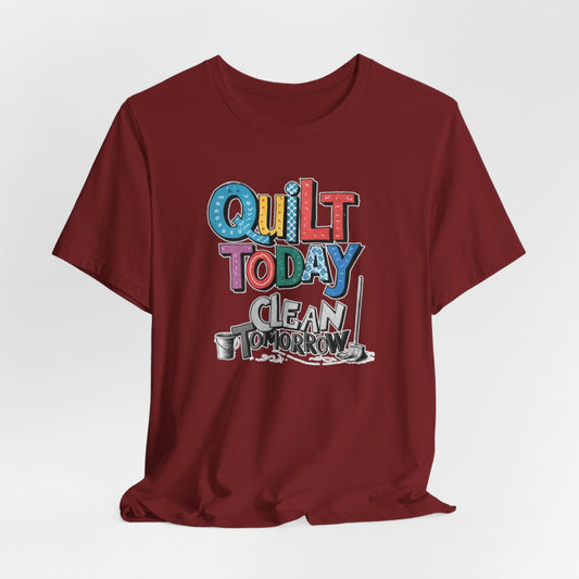 A Cardinal funny quilting T-Shirt with the phrase Quilt Today, Clean Tomorrow in a bold and cheerful font with a broom off to the side
