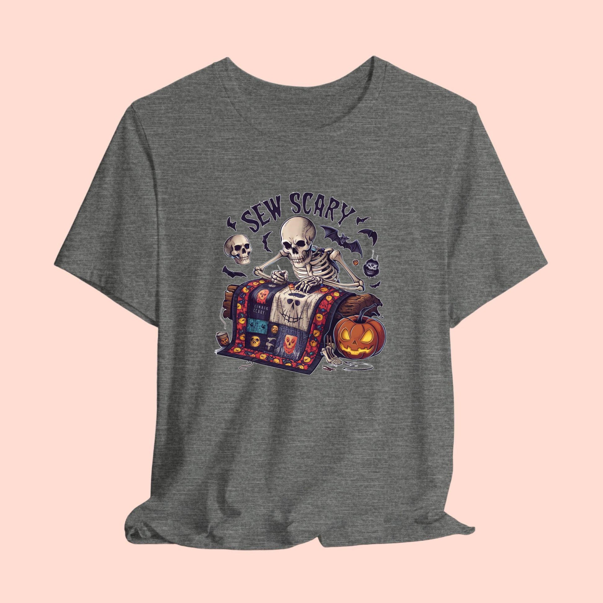 A Halloween Quilting T-Shirt featuring a skeleton sewing Halloween quilt. Colorful patchwork with spooky motifs. Bats and pumpkins surround skeleton. Text reads "Sew Scary". Ideal for quilters who love Halloween.