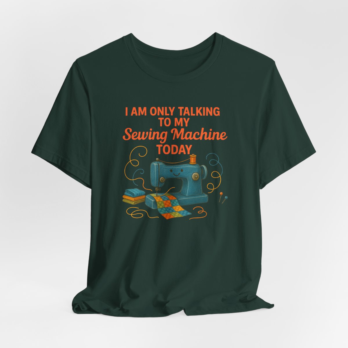 A Forest Short Sleeve T-Shirt featuring a smiling sewing machine with colorful fabric and playful thread swirls