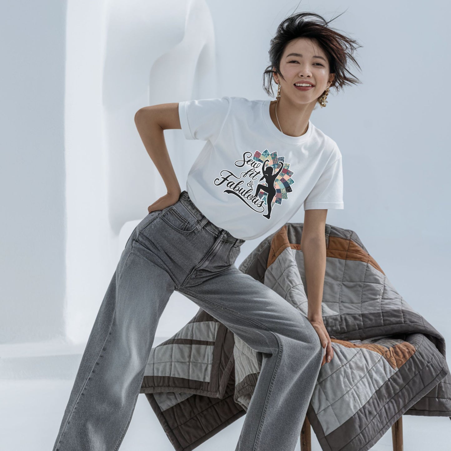 A T-Shirt featuring a black silhouette of woman with raised arms against colorful patchwork background. Text reads "Sew fit & Fabulous" in stylized script.