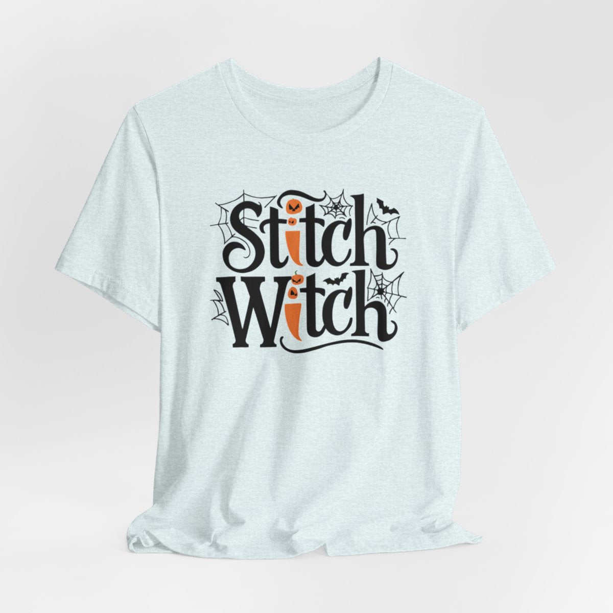 T-shirt design with "Stitch Witch" text in Halloween-themed typography. Jack-o'-lanterns, spiderwebs, and bats decorate the letters. The "i" in "Stitch" resembles a sewing needle. Ideal for quilters who love Halloween.