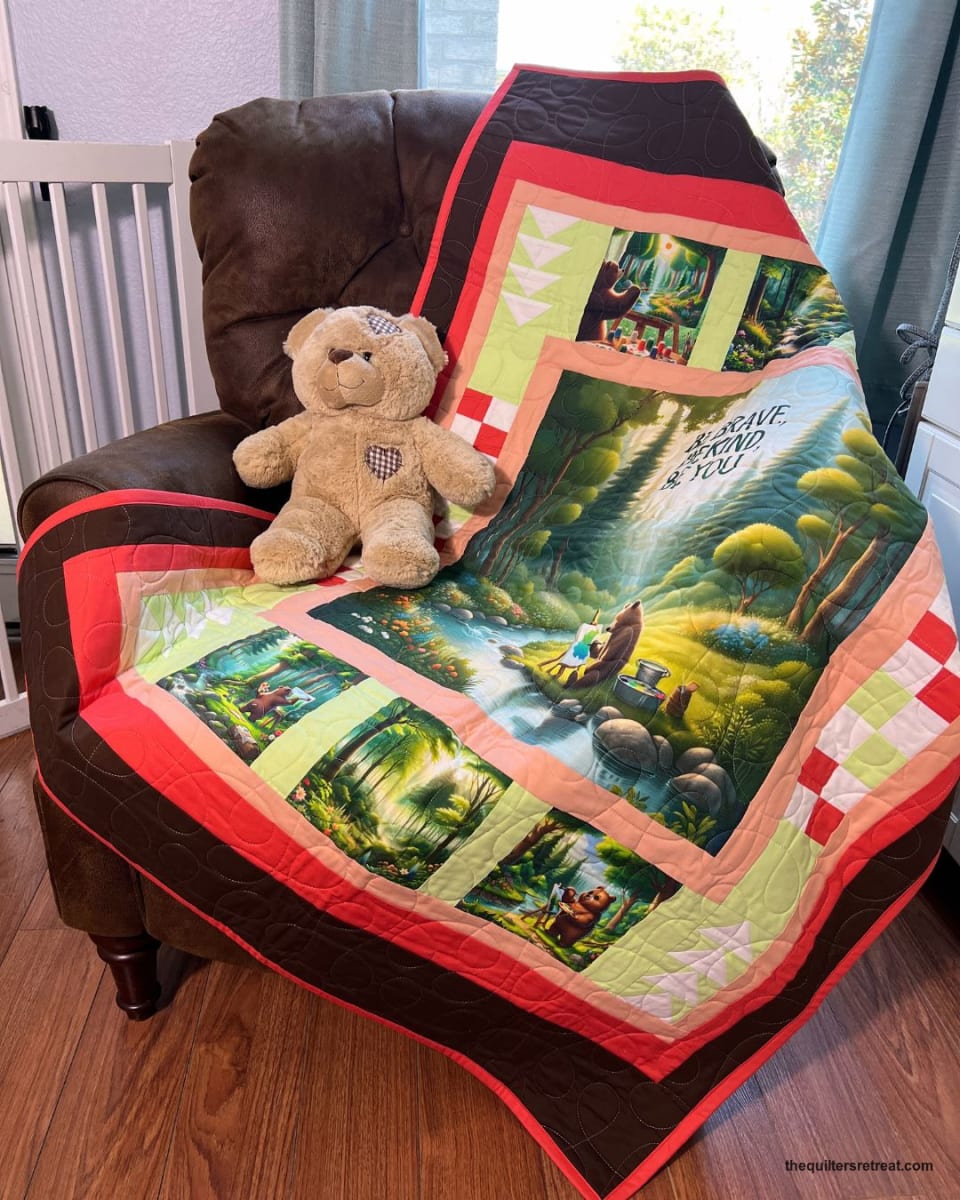 Be Kind Bear quilt made from the panel, coral border, on a chair with a teddy bear