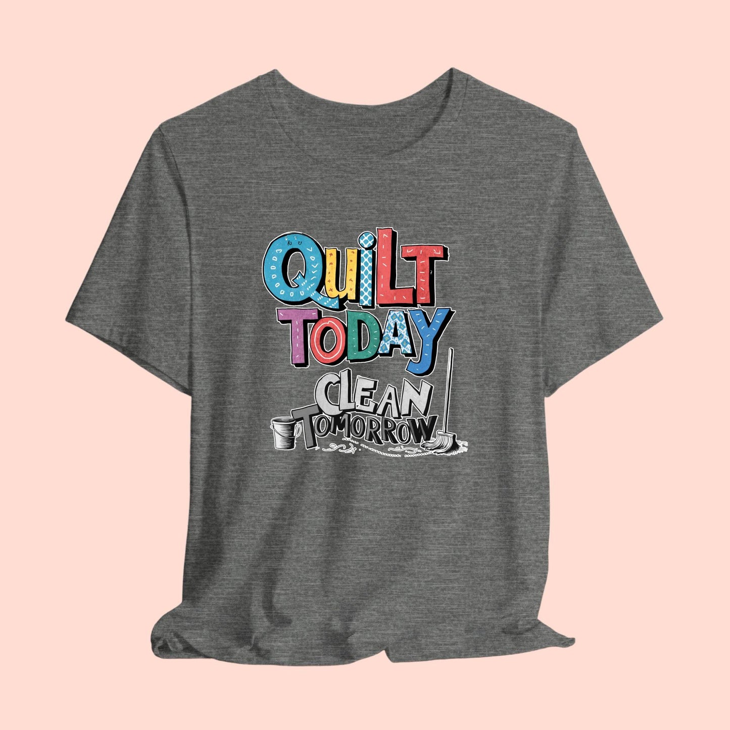 A funny quilting T-Shirt with the phrase Quilt Today, Clean Tomorrow in a bold and cheerful font with a broom off to the side