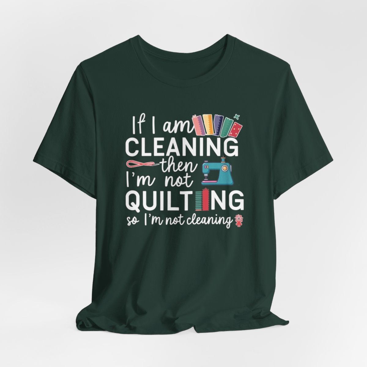 A Forest funny quilting T-Shirt with the phrase If I am Cleaning then I'm not Quilting in a bold and cheerful font with images of quilting icons and supplies