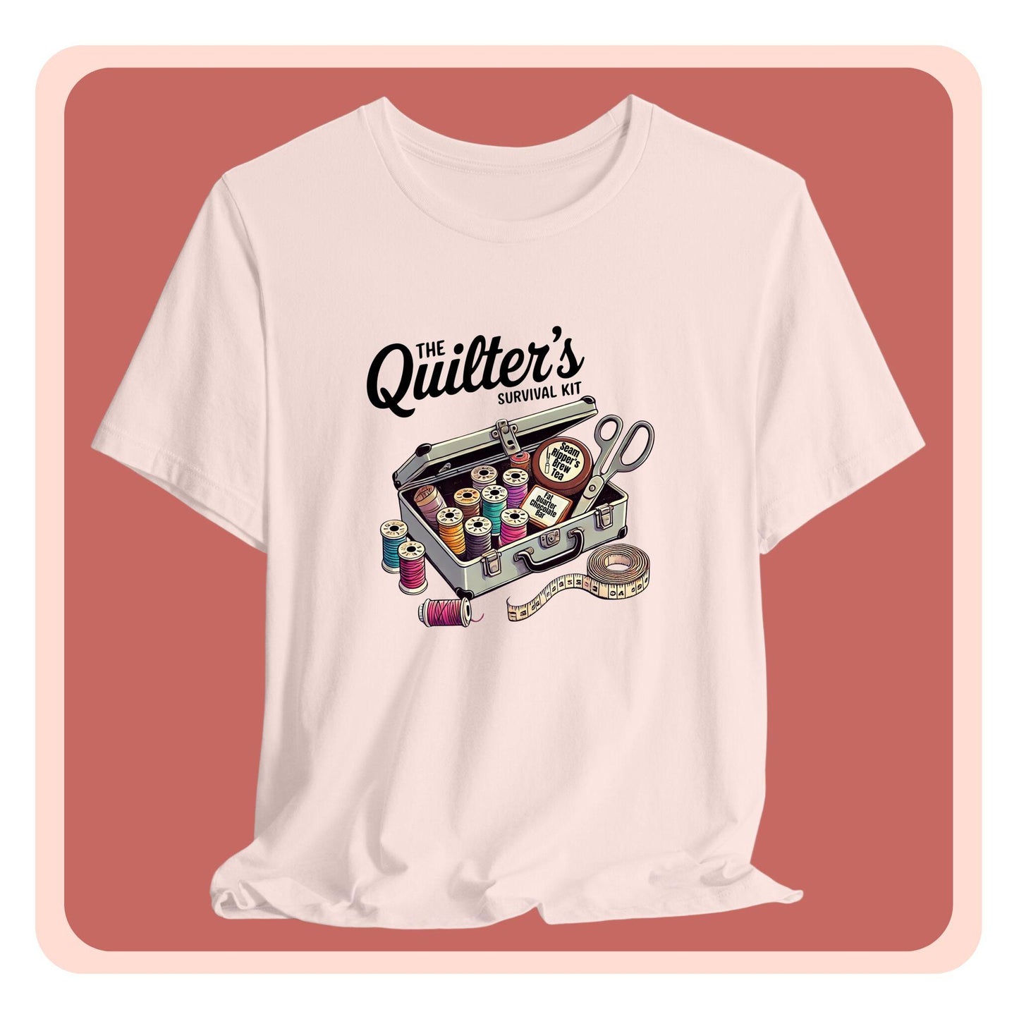 A t-shirt featuring a whimsical illustration of a quilter’s survival kit with colorful thread spools, scissors, and a tape measure, perfect for sewing and quilting enthusiasts.
