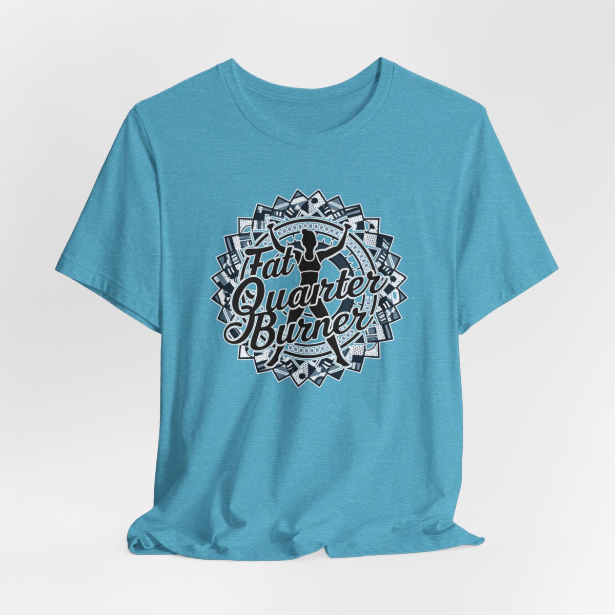 A Heather Aqua T-Shirt featuring a patchwork border surrounding silhouette of woman lifting weights. Text reads "Fat Quarter Burner" in bold script.