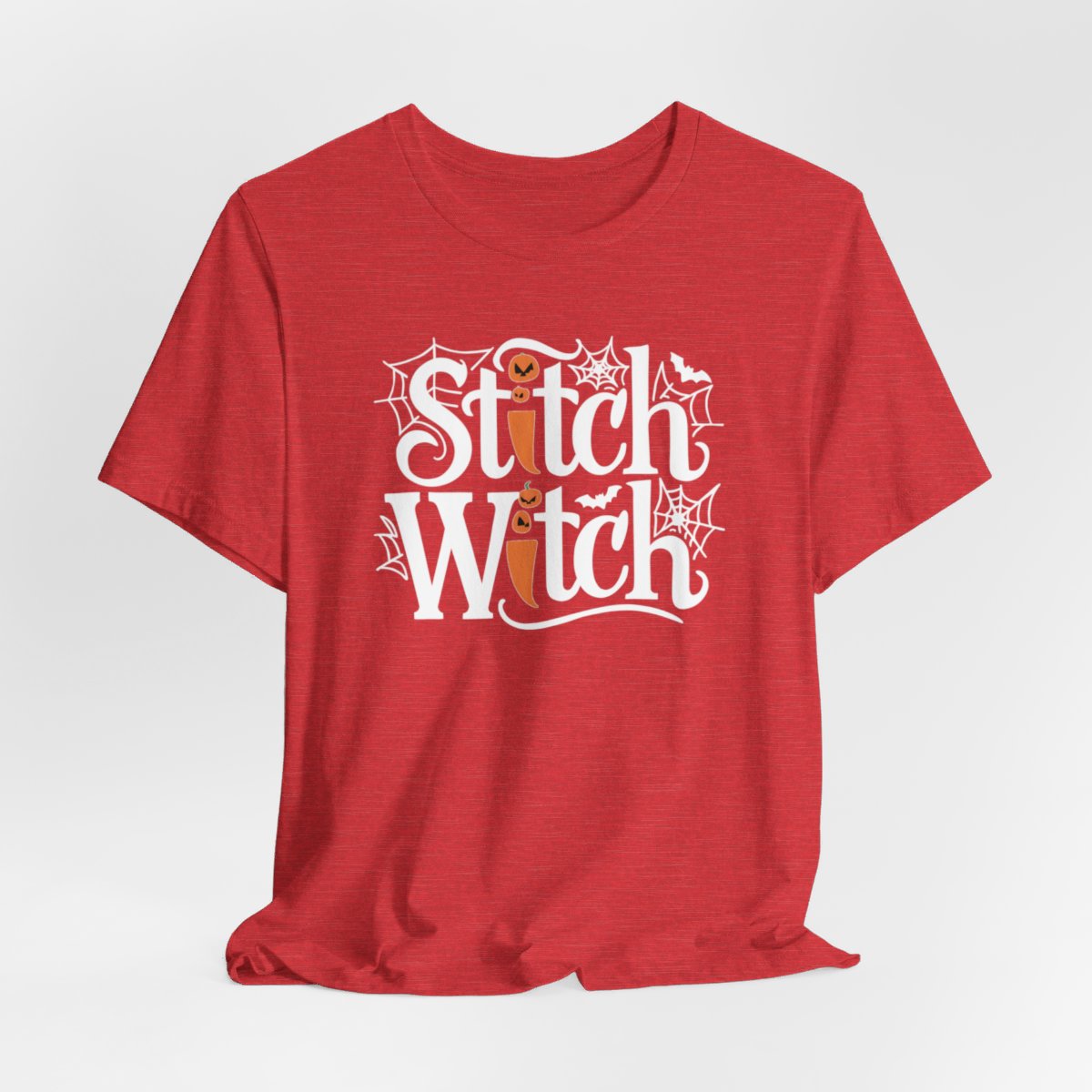 T-shirt design with "Stitch Witch" text in Halloween-themed typography. Jack-o'-lanterns, spiderwebs, and bats decorate the letters. The "i" in "Stitch" resembles a sewing needle. Ideal for quilters who love Halloween.