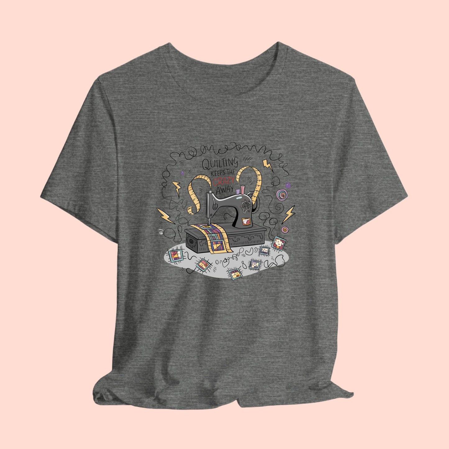 A T-Shirt with a vintage sewing machine, measuring tape heart, and text "Quilting Keeps the Crazy Away" amidst swirls and quilting motifs.