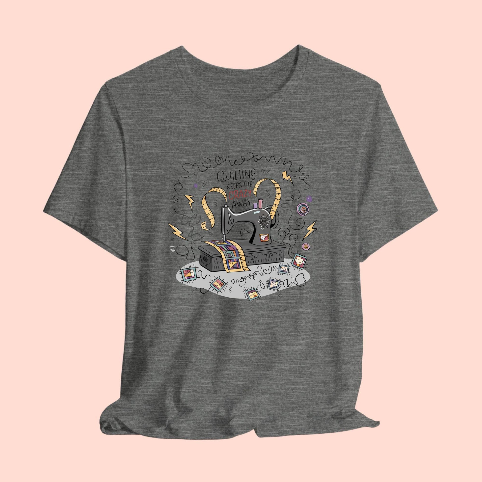A T-Shirt with a vintage sewing machine, measuring tape heart, and text "Quilting Keeps the Crazy Away" amidst swirls and quilting motifs.
