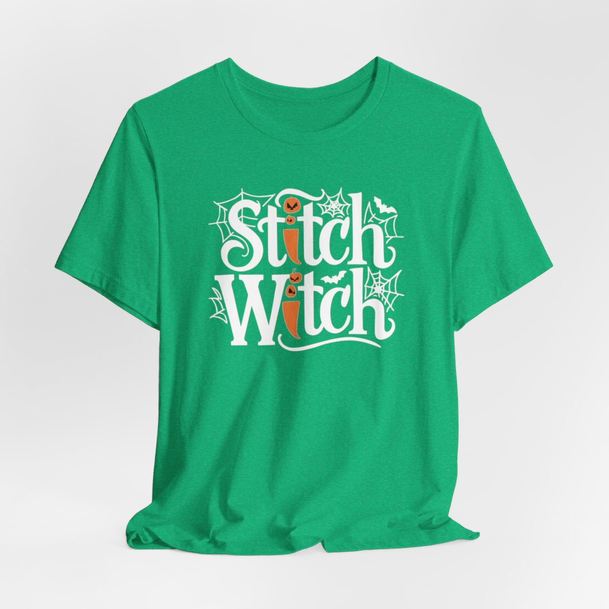 T-shirt design with "Stitch Witch" text in Halloween-themed typography. Jack-o'-lanterns, spiderwebs, and bats decorate the letters. The "i" in "Stitch" resembles a sewing needle. Ideal for quilters who love Halloween.
