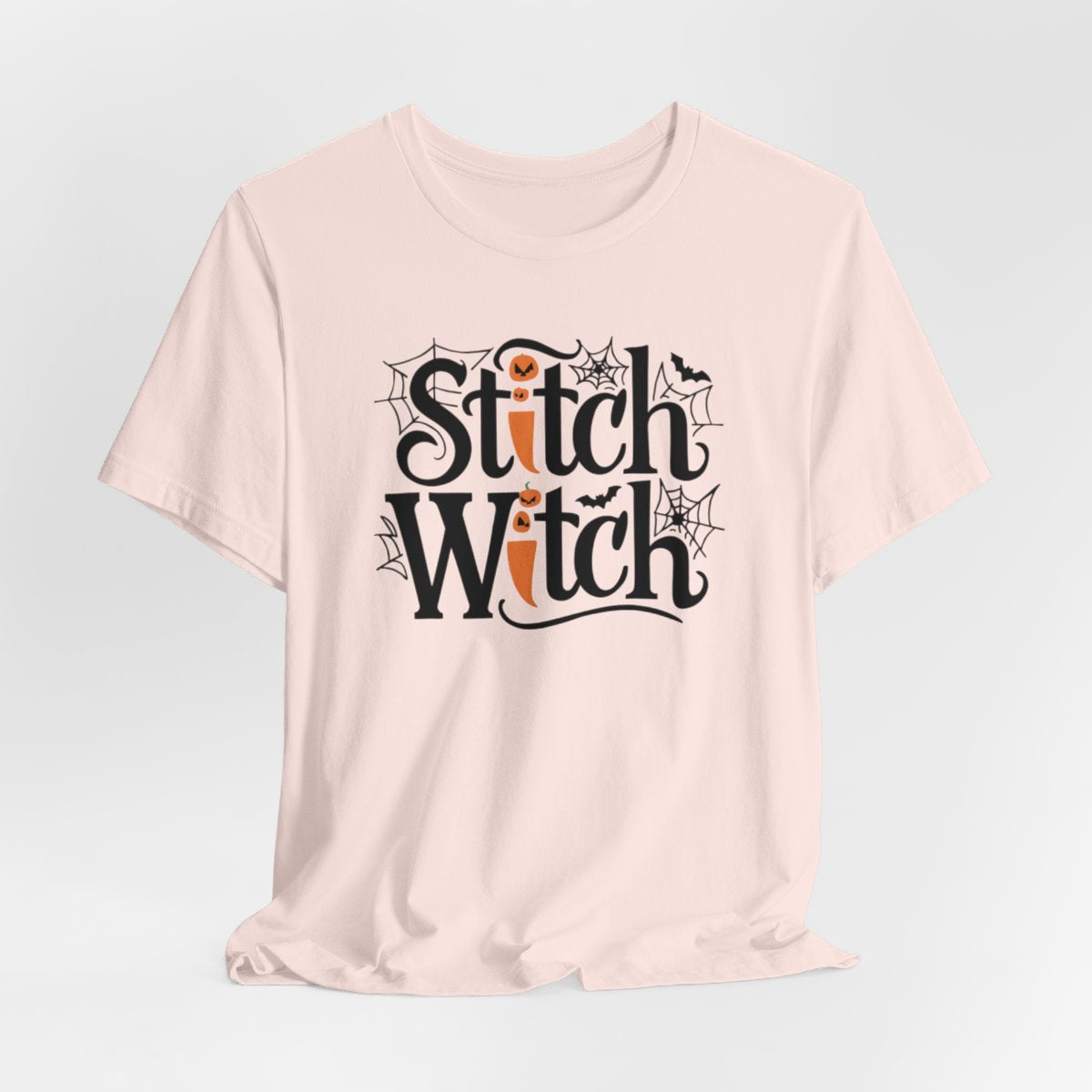 T-shirt design with "Stitch Witch" text in Halloween-themed typography. Jack-o'-lanterns, spiderwebs, and bats decorate the letters. The "i" in "Stitch" resembles a sewing needle. Ideal for quilters who love Halloween.