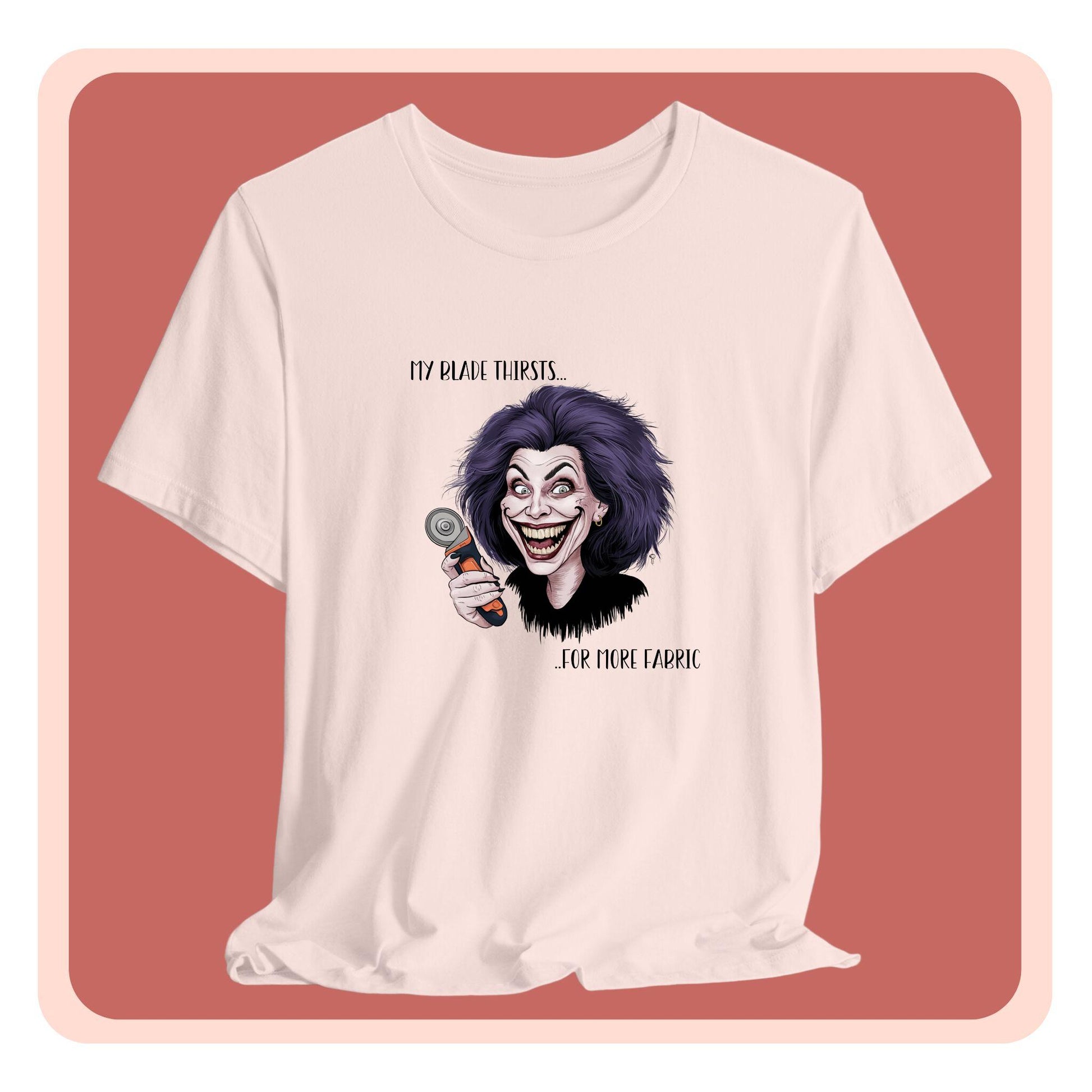 A T-shirt showing a cartoonish character with wild purple hair and an exaggerated grin, holding a rotary cutter. Text reads "My blade thirsts... for more fabric", humorously depicting a quilter's endless desire for new materials.