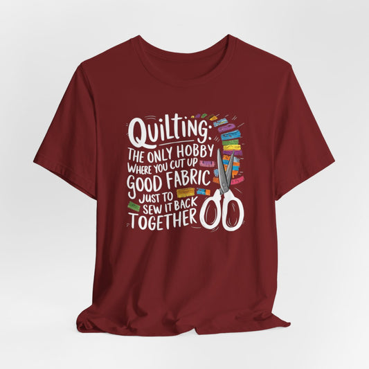A Cardinal Quilting-themed T-Shirt with text "Quilting: The Only Hobby Where You Cut Up Good Fabric Just to Sew it Back Together" surrounded by colorful fabric scraps and scissors.