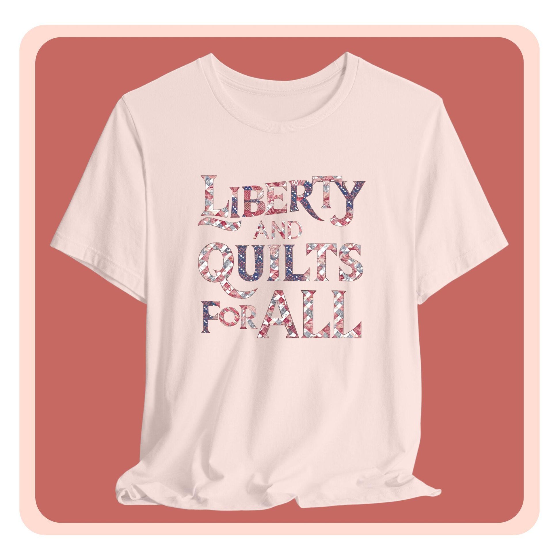 A T-shirt featuring text "LIBERTY AND QUILTS FOR ALL" in large decorative letters filled with various quilt patterns in red, white, and blue.