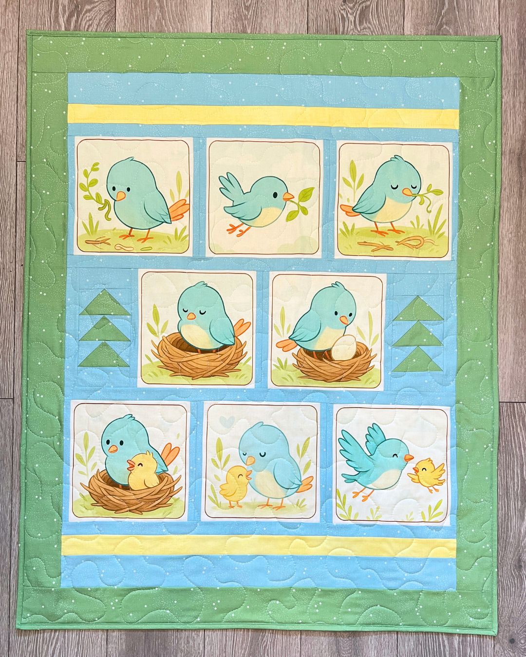 Little Birdie Makes a Nest quilt panel sewn into a finished bluebird nursery quilt