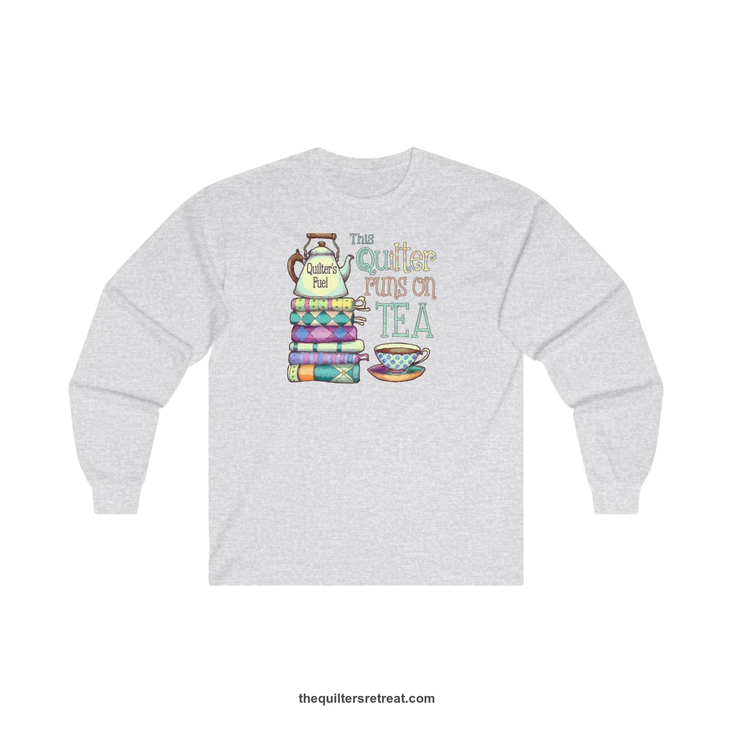 A Ash Long Sleeve T-Shirt with a stack of colorful quilts with teapot and cup, whimsical "This Quilter Runs on Tea" text