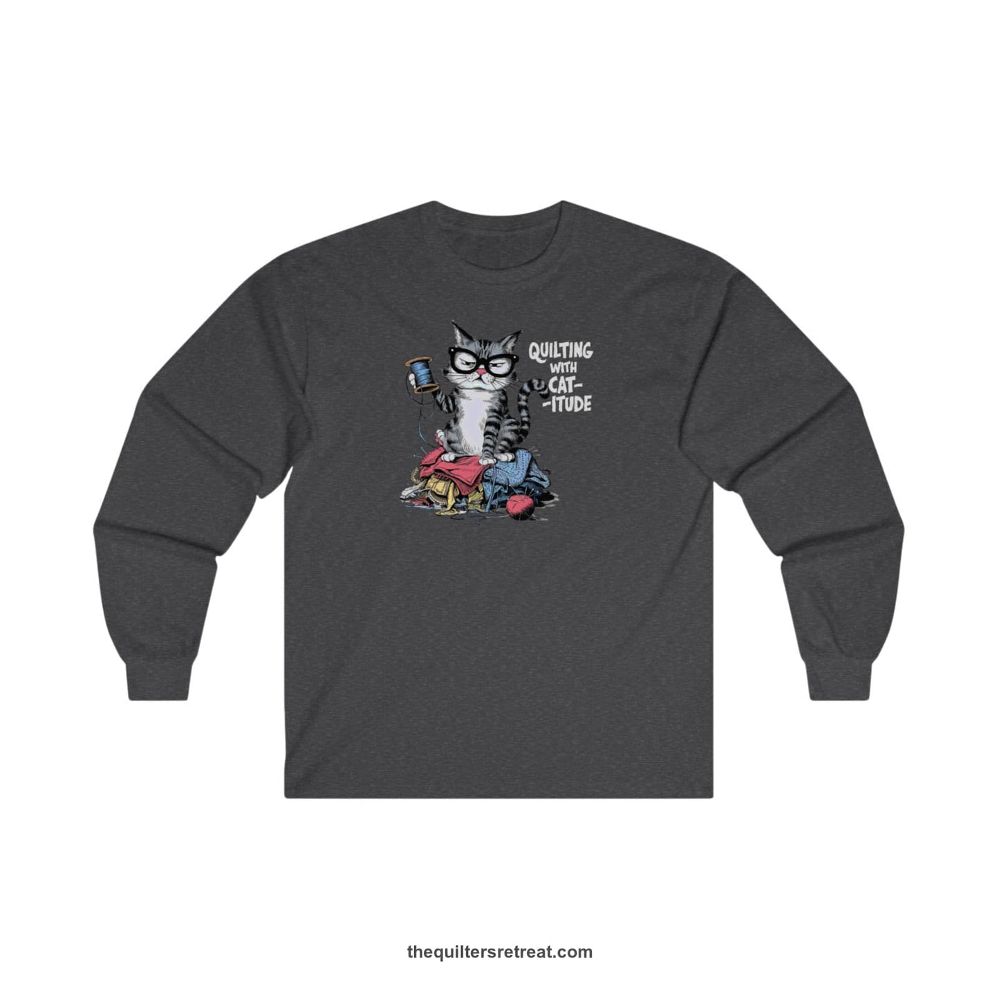 A Dark Heather Long Sleeve T-Shirt with a grumpy cat holding thread spool atop fabric pile with "Quilting with Cat-itude" text