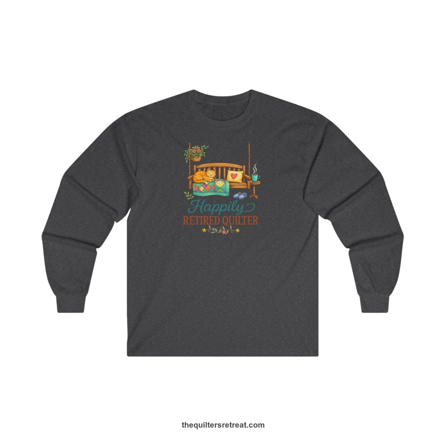 A Dark Heather Long Sleeve T-Shirt with a hanging bench with cozy cat and quilt, surrounded by plants, "Happily Retired Quilter" text