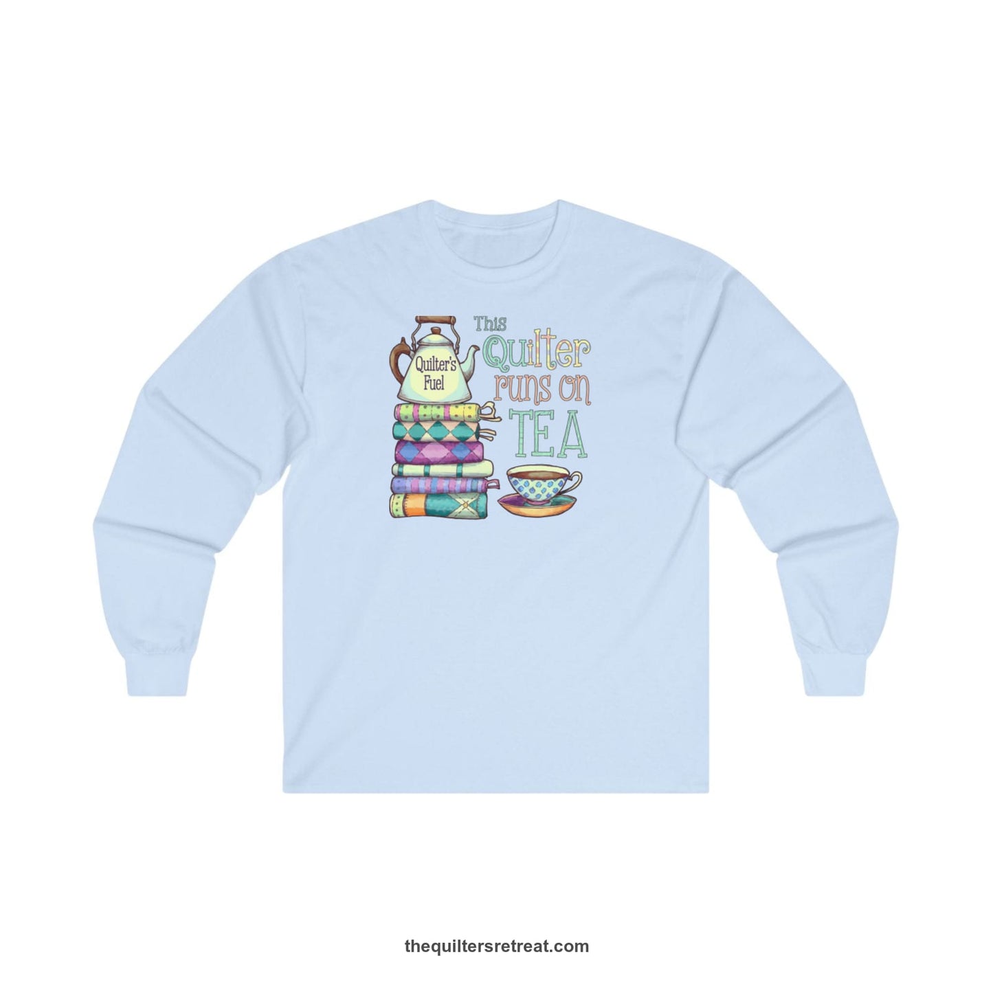 A Light Blue Long Sleeve T-Shirt with a stack of colorful quilts with teapot and cup, whimsical "This Quilter Runs on Tea" text