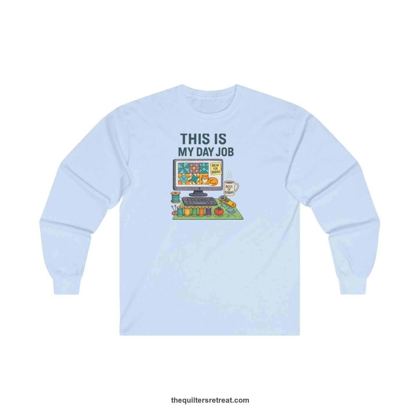 A Light Blue Long Sleeve T-Shirt with a computer quilt design, cat illustration, "THIS IS MY DAY JOB" text with sewing tools, playful style