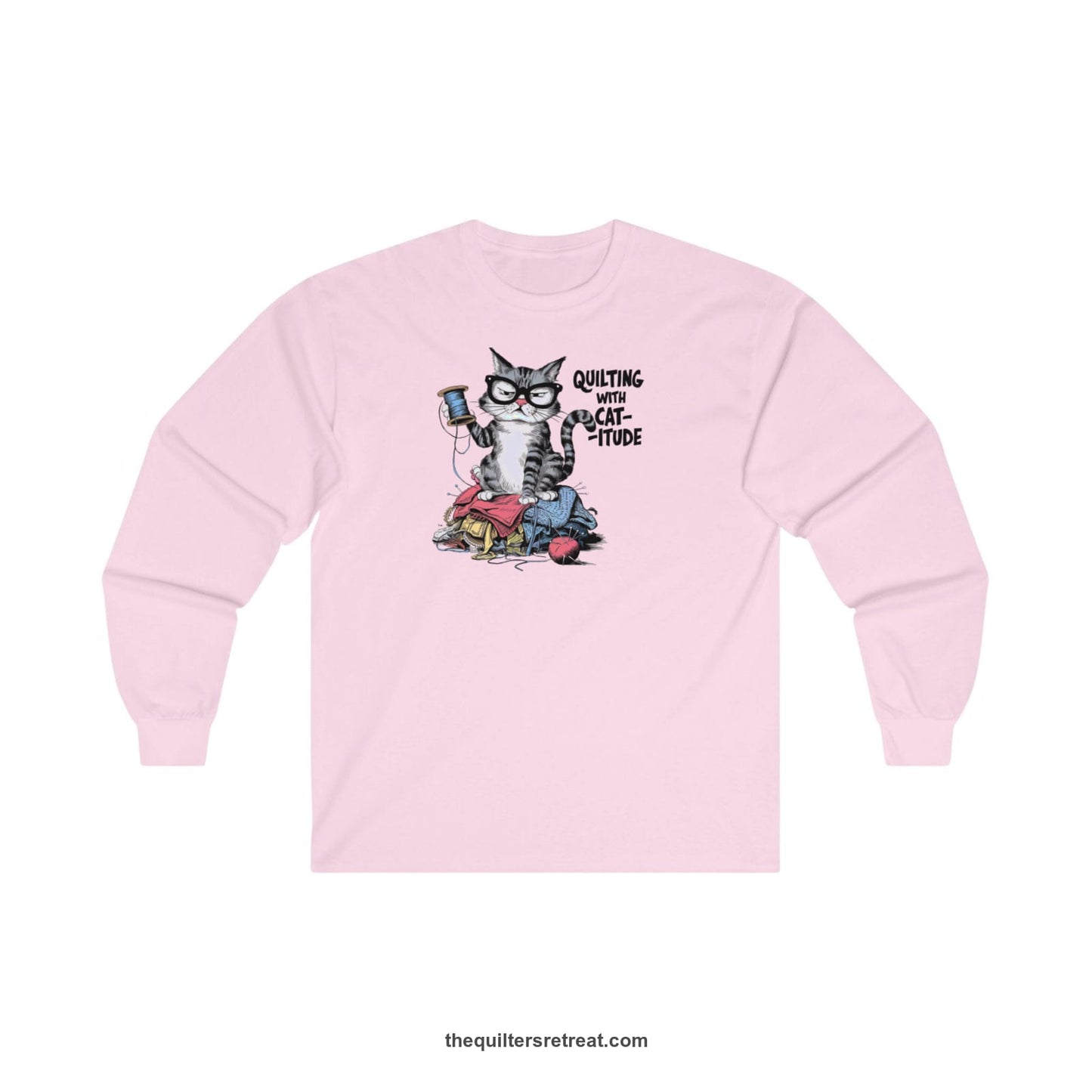 A Light Pink Long Sleeve T-Shirt with a grumpy cat holding thread spool atop fabric pile with "Quilting with Cat-itude" text