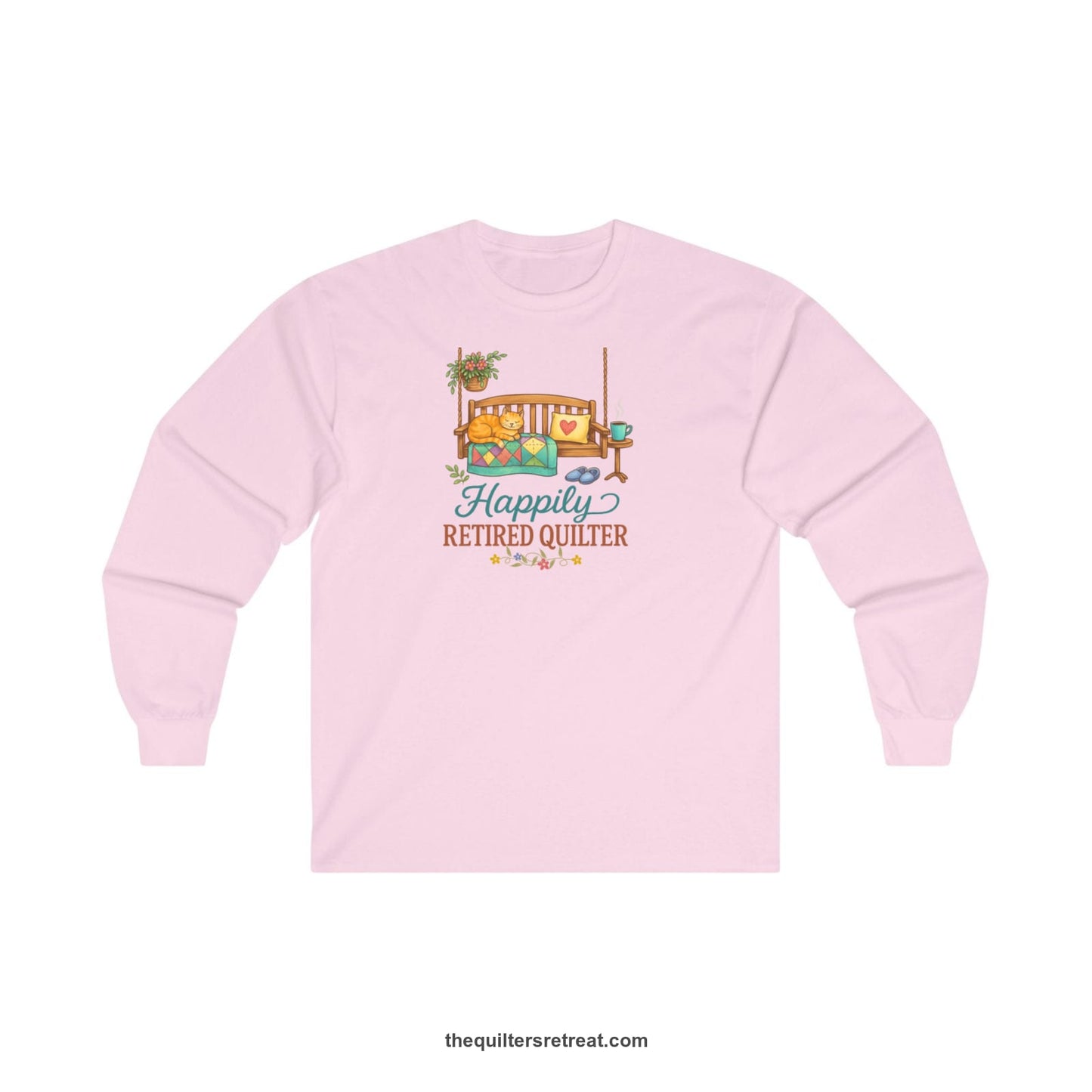A Long Sleeve T-Shirt with a hanging bench with cozy cat and quilt, surrounded by plants, "Happily Retired Quilter" text