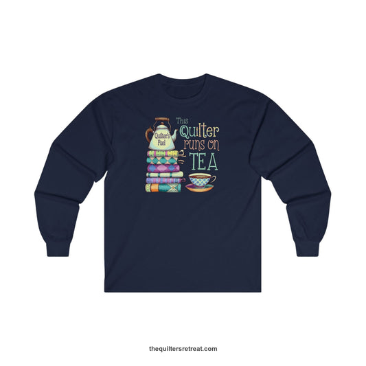 A Long Sleeve T-Shirt with a stack of colorful quilts with teapot and cup, whimsical "This Quilter Runs on Tea" text