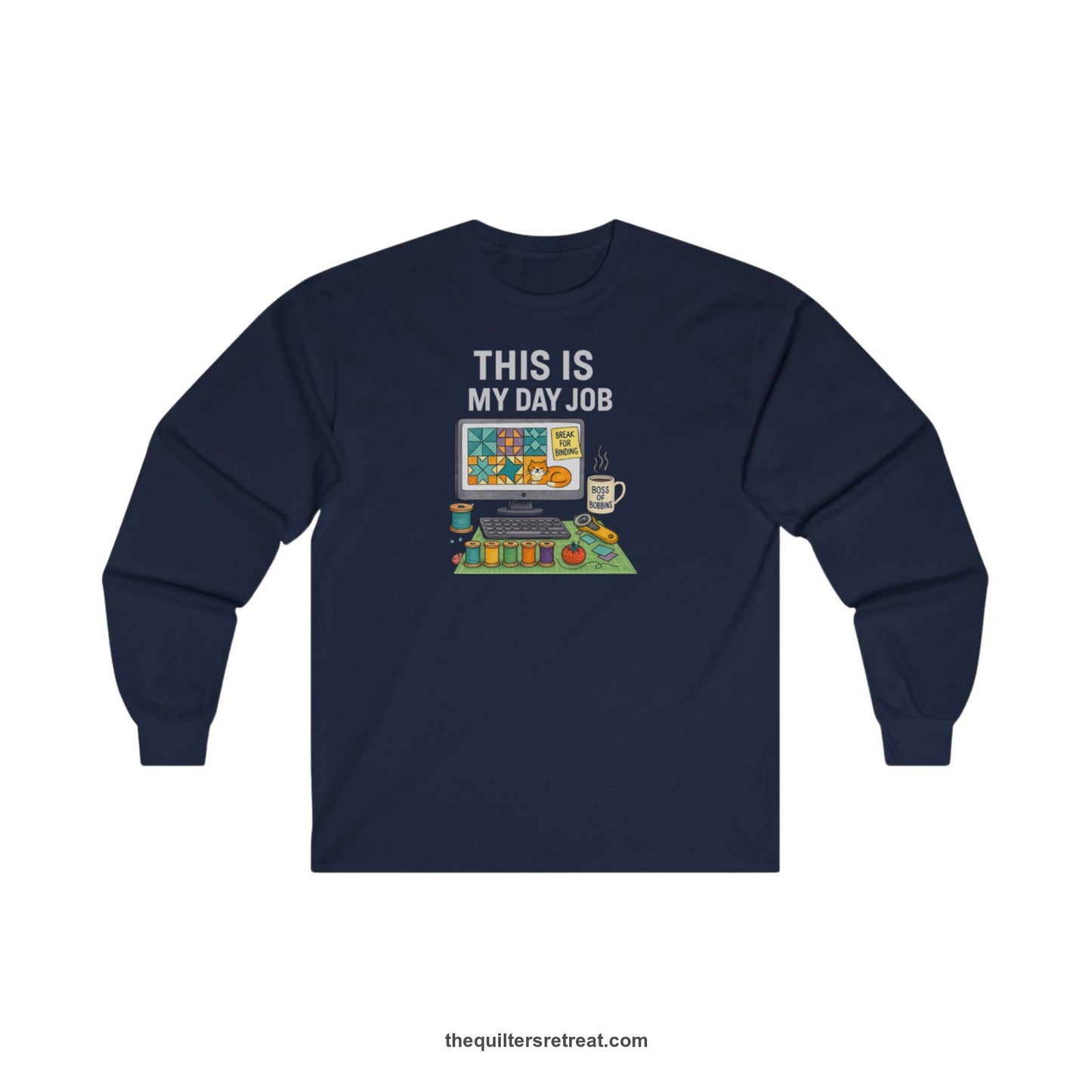 A Navy Long Sleeve T-Shirt with a computer quilt design, cat illustration, "THIS IS MY DAY JOB" text with sewing tools, playful style