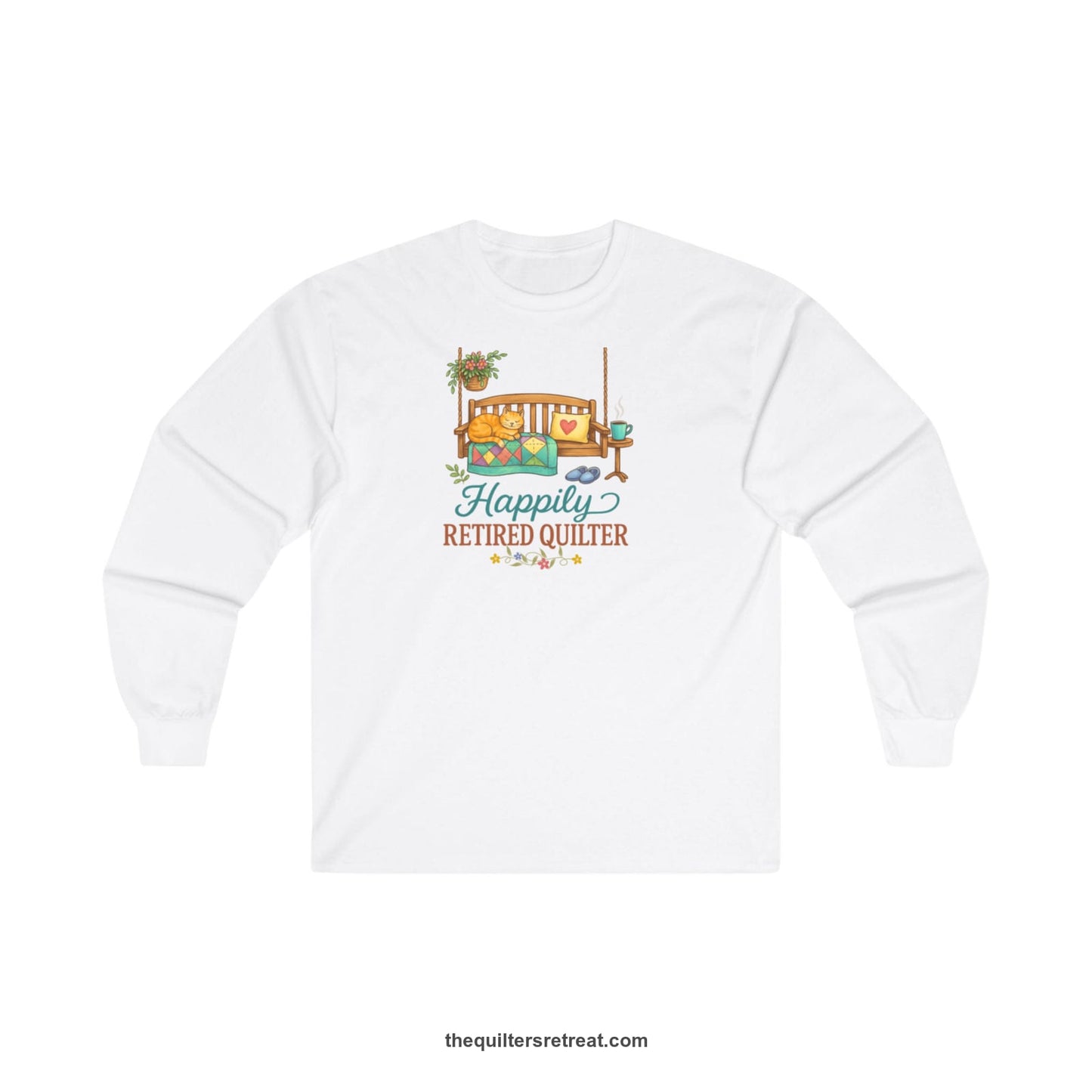 A White Long Sleeve T-Shirt with a hanging bench with cozy cat and quilt, surrounded by plants, "Happily Retired Quilter" text