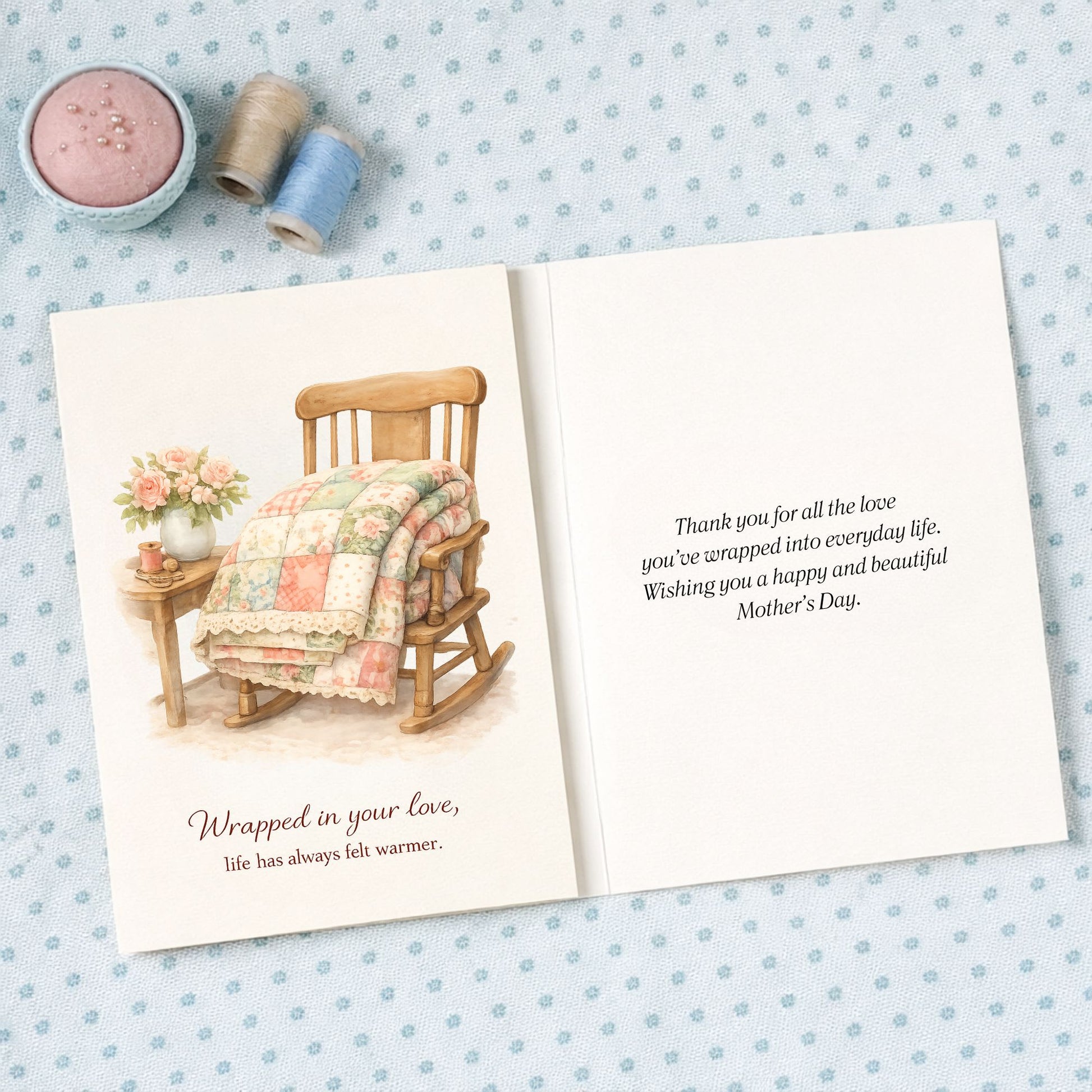 Quilter Gift: A Mother's Day Card - Soft with Wooden rocking chair with quilt and flowers, cozy vintage feel, "Wrapped in your love" text.