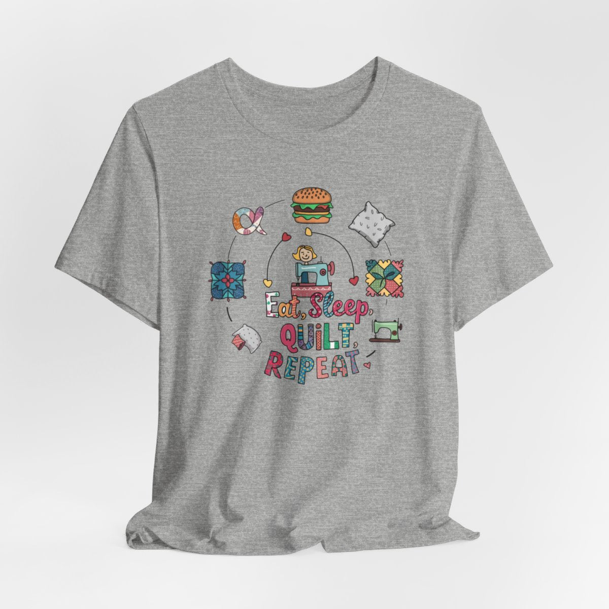 An Athletic Heather funny quilting T-Shirt with the phrase Eat, Sleep, Quilt, Repeat  showing the cycle of a quilter's day with eating, sleeping, and quilting