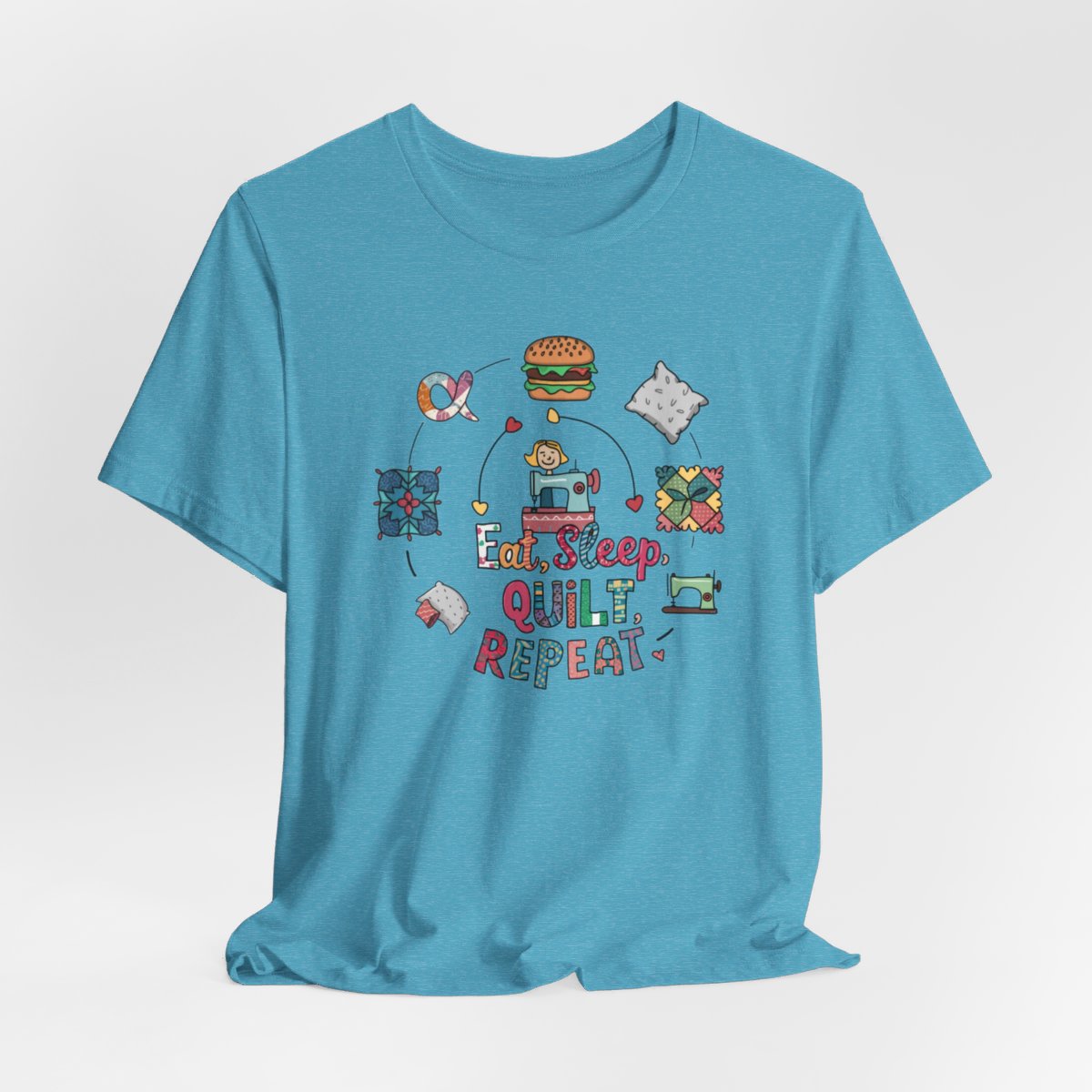 A Heather Aqua funny quilting T-Shirt with the phrase Eat, Sleep, Quilt, Repeat  showing the cycle of a quilter's day with eating, sleeping, and quilting