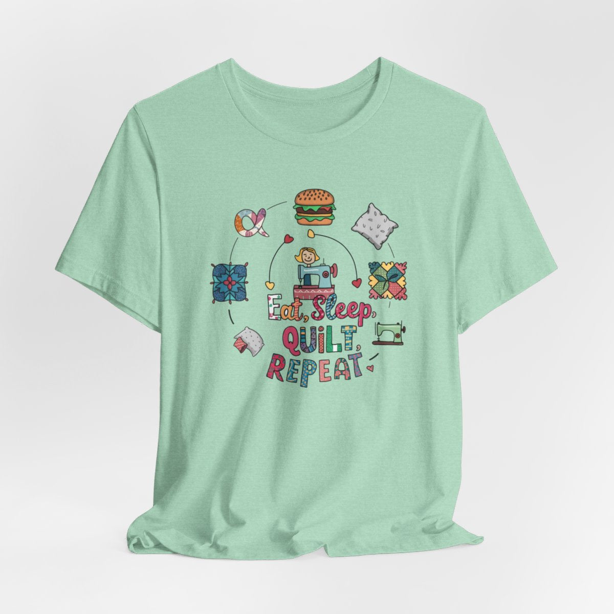 A Heather Mint funny quilting T-Shirt with the phrase Eat, Sleep, Quilt, Repeat  showing the cycle of a quilter's day with eating, sleeping, and quilting